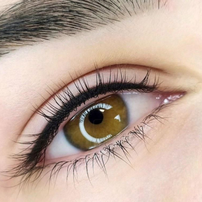 Olho castanho com pestanas longas e maquilhadas com rímel preto