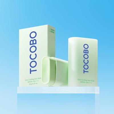 Produto TOCOBO Cica Cooling Sun Stick verde claro sobre pedestal transparente