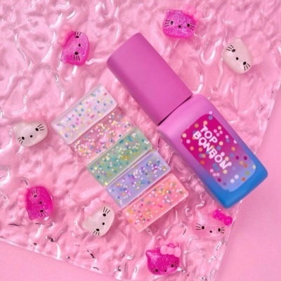 Frasco de verniz rosa com amostras coloridas e acessórios decorativos em fundo rosa.