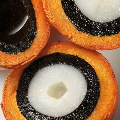 Frutas com casca laranja e interior preto e branco cortadas ao meio