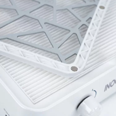 Grelha metálica cinza com bordas brancas sobre placa branca com controle