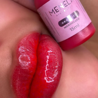 Lábios vermelhos brilhantes com frasco rosa de batom com rótulo e texto visível