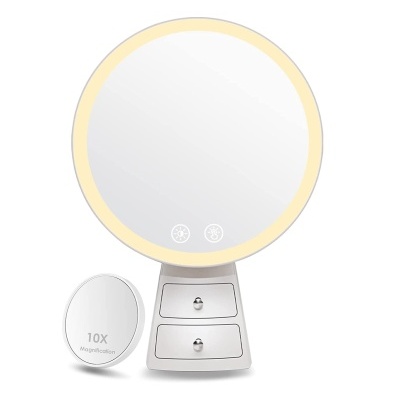 Espelho de maquilhagem redondo iluminado com suporte branco e gavetões.