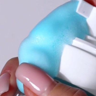 Mãos segurando mini embalagem branca com espuma azul