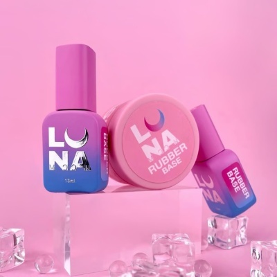 Produtos de unhas LUNA com base de borracha em rosa, roxo e azul, sobre suporte transparente com gelo artificial