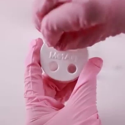 Montagem de um porta-copos com argolas brancas e tampas pretas em fundo branco e vermelho