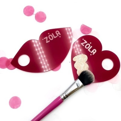 Pontas de acrílico vermelho com texto ZOLA e pincel de maquilhagem rosa