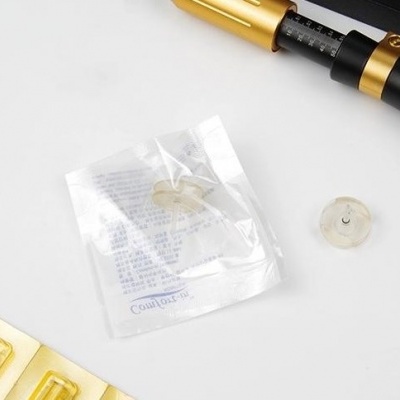 Pipetas douradas e esferas de silicone com embalagem plástica sobre fundo claro