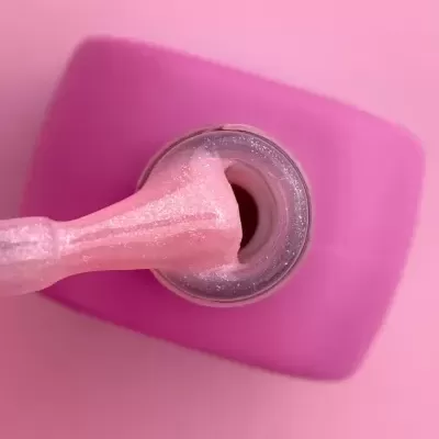 Frasco de verniz de unhas rosa brilhante aberto com aplicador
