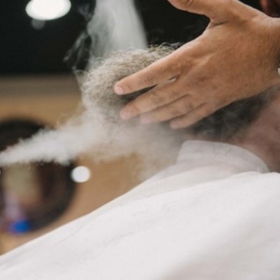 Pessoa a receber vapor no cabelo ou barba com mãos próximas