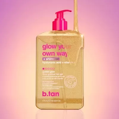 Frasco dourado de gel autobronzeador b.tan com doseador rosa e texto colorido em fundo rosa.