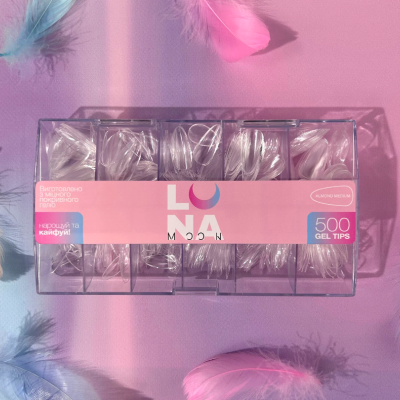 Caixa transparente com gel tips para unhas em fundo rosa com penas coloridas