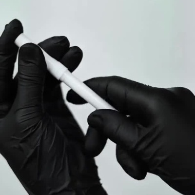 Caneta branca de aplicação de produto para a pele, com texto visível, sendo usada ao redor da boca.