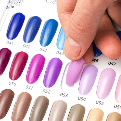 Paleta de amostras de verniz de unhas coloridas com dedo a tocar amostra lilás nº 054