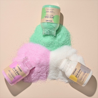 Frascos com sal grosso colorido verde, rosa e branco espalhado