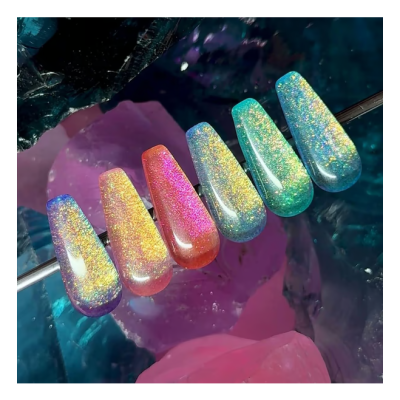 Unhas postiças coloridas com brilho holográfico em gradiente sobre cristais coloridos