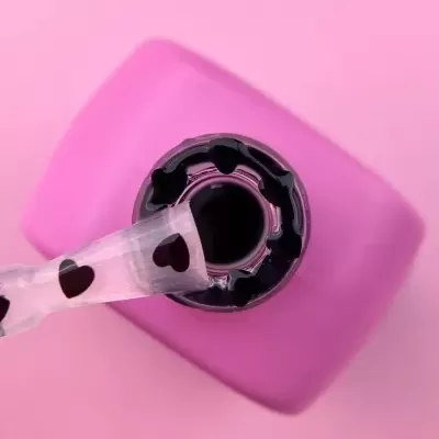 Verniz de unhas rosa com pincel decorado com corações pretos