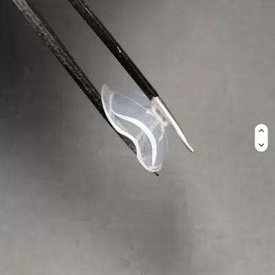 Pinça segurando peça transparente curva