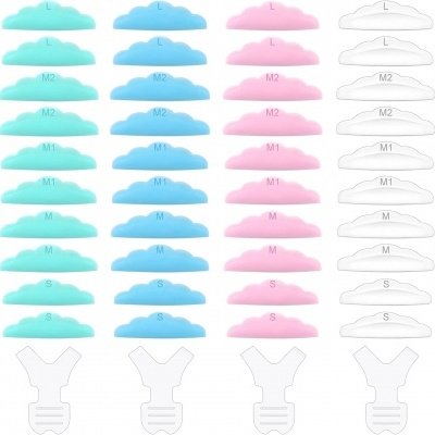 Quatro colunas de protetores auriculares em forma de nuvem em verde, azul, rosa e branco com tamanhos impressos, acompanhados por bases brancas.