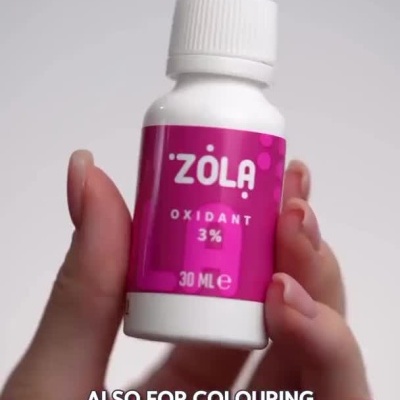 Mulher a apresentar frascos rosa de oxidante Zola para coloração de cabelo