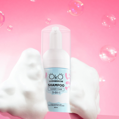 Frasco de champô espumoso ÖKÖ Lash & Brow Shampoo com espuma branca e fundo rosa