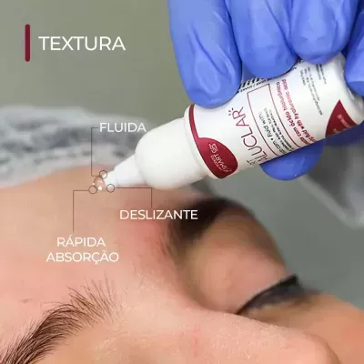 Frasco branco de creme com aplicador sobre testa de pessoa usando luva azul