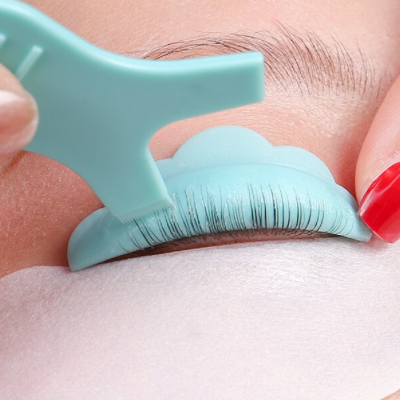 Dispositivo azul claro a aplicar pestanas falsas em pele clara