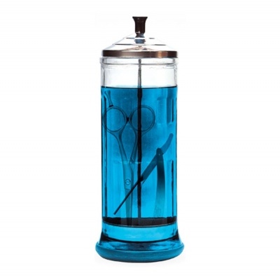 Frasco de vidro com instrumentos em líquido azul e tampa metálica