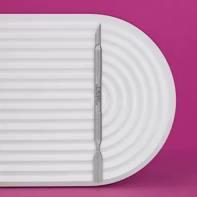 Espátula dupla de metal sobre prato branco texturizado