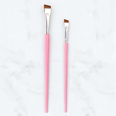 Dois pincéis para maquiagem com cabo rosa sobre fundo branco
