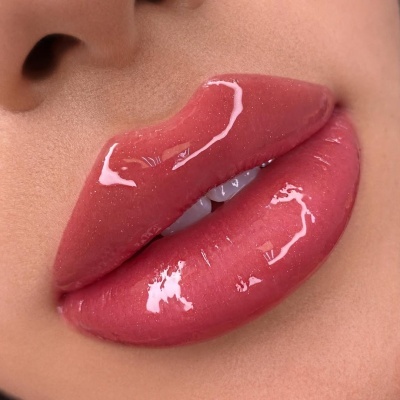 Lábios masculinos com brilho labial rosa translúcido e pele visível