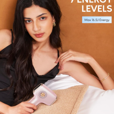 Mulher jovem segura dispositivo eletrônico rosa claro contra fundo castanho