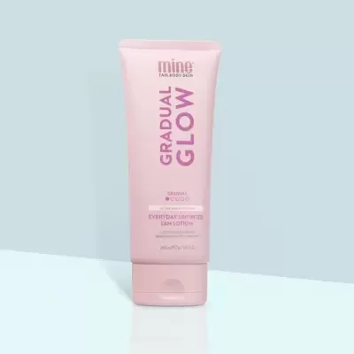 Frasco rosa de creme para bronzeado gradual em fundo azul
