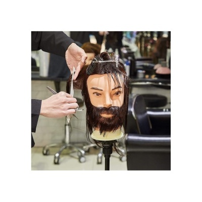 Cabeça de treino com cabelo e barba sendo cortada por barbeiro em salão
