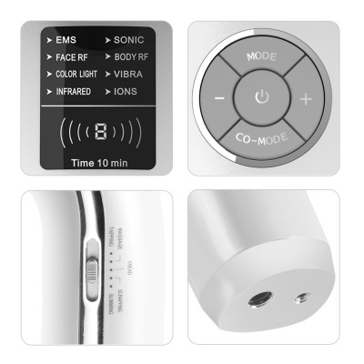 Dispositivo eletrônico branco com painel digital, controlo circular, interruptor lateral e base com portas metálicas