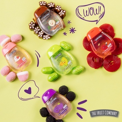 Frascos coloridos de gel antisséptico com doces artísticos sobre fundo amarelo