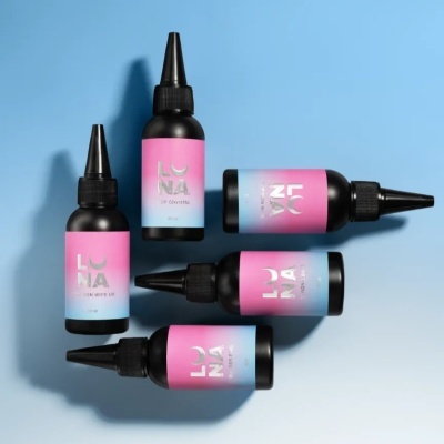 Cinco frascos pretos com tampa aplicadora e etiquetas rosa e azul com textos LUNA e descrições do produto