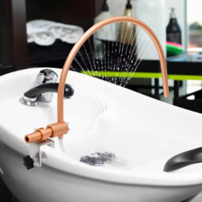 Pia branca com torneira e dispositivo de spray em arco cobre a jorrar água