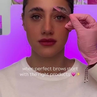 Mulher aplicando produtos para sobrancelhas com texto em inglês e produtos ao fundo