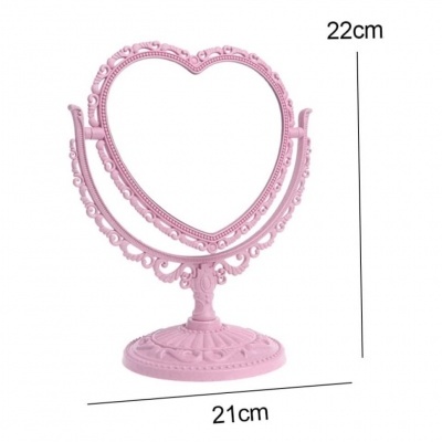 Espelho de mesa rosa em forma de coração com base decorativa.