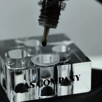 recipiente transparente em acrílico com pipeta aplicando líquido escuro