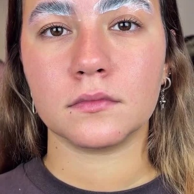 Mulher aplicando produtos nas sobrancelhas com pincel e algodão