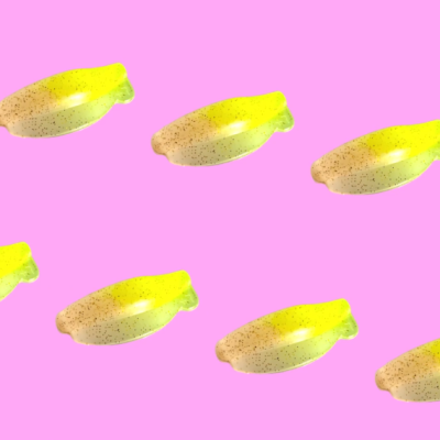 Padrão repetitivo de bananas amarelas e castanhas sobre fundo rosa