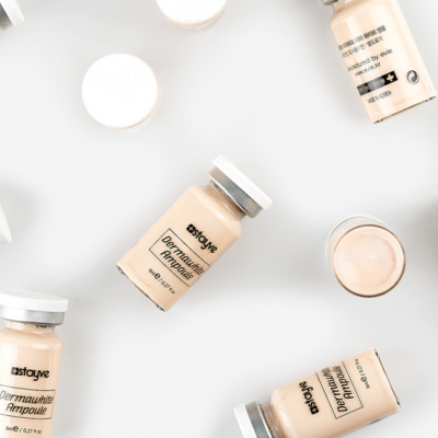 Frascos pequenos de vidro com líquido beige e tampa branca, rotulados Dermapure Impresion Probioticos