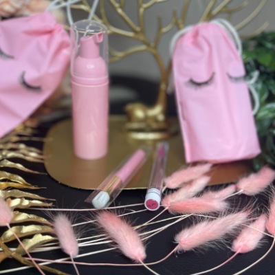 Produtos de maquilhagem em tons rosa com saco de tecido rosa e decoração dourada