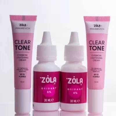 Produtos clareador de sobrancelhas ZÒLA x MAKAREVICH com tubos e garrafas em rosa e branco.