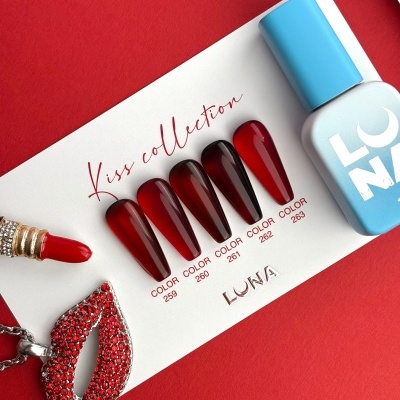 Cartão com amostras de verniz vermelhas, frasco azul e pingente vermelho