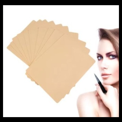 Dez cartões bege claro em leque ao lado do rosto de mulher segurando caneta preta