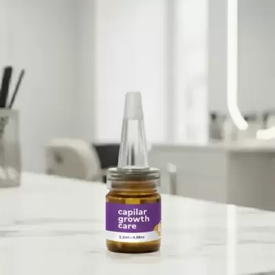 Frasco pequeno de vidro castanho com rótulo roxo sobre mesa de mármore branca