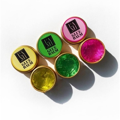 Três frascos redondos de pomada colorida GLUE BALM LAKA em fundo branco